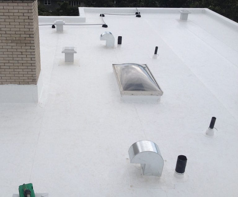 White TPO flat commercial roof with skylights and vents — Heritage Roofing TX